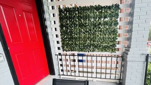 Een rode deur, een wit hekwerk en een zwart metalen poort.