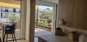 Ein Balkon mit Holzgeländern, einem Korbwannenstuhl und einem Stuhl.