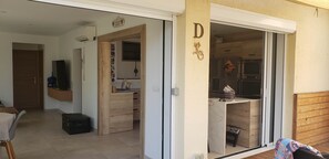 Eine moderne Küche mit Holzausstattung, integriertem Backofen und einer Glastür, die auf einen Balkon führt.
