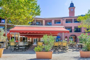 An outdoor patio area with tables and chairs, surrounded by potted plants. - Ardeche House With Spacious Terrace for 8 (Grospierres)