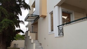 Ein modernes Gebäude mit Treppe, einer kleinen Außenbereicherung und einem Baum.
