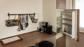 Una kitchenette equipada con cafetera, hervidor de agua y refrigerador con dispensador de agua.