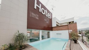 A hotel with a pool, a sign reading 'Hotel', and a modern architectural design. - Hotel Metropolitano (Coronel Fabriciano)