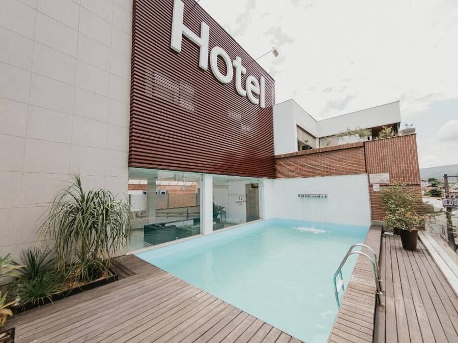 Un hotel con piscina, un cartel que dice 'Hotel' y un diseño arquitectónico moderno.
