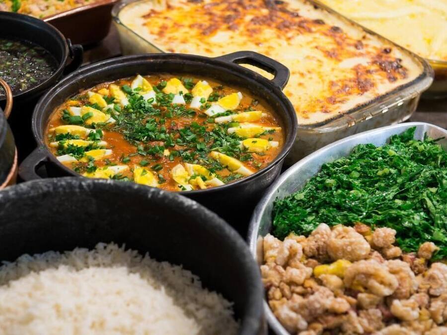 A variety of dishes including a stew with eggs, a casserole, and a bowl of rice.