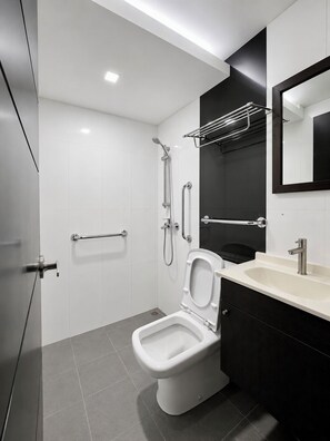 A modern bathroom with a toilet, sink, and shower.
