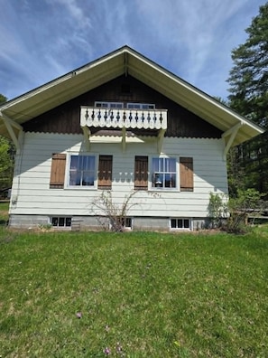 A two-story house with a gabled roof, a front porch, and a small front yard. - Serene 3-bedroom house20-30 minutes from Lake George and Saratoga Springs (Corinth)