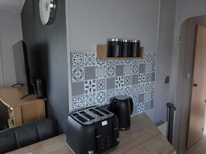 Eine Küchenzeile mit Toaster, Wasserkocher und Kaffeemaschine auf der Arbeitsfläche.