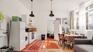 A compact living space with a kitchen, dining area, and a sofa. - Authentic apartment - Historic Orbec (Orbec)