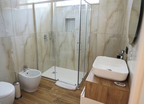 Een douche, een haardroger, een bidet, handdoeken