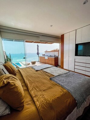 A bedroom with a large bed, a TV, and a view of the ocean. - Oceanview 2BR & Terrace in Punta Hermosa (Punta Hermosa)