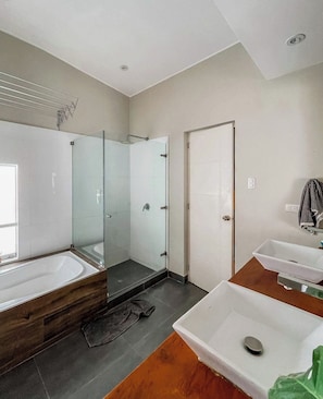 A modern bathroom with a glass-enclosed shower, a bathtub, and a vanity with a sink. - Oceanview 2BR & Terrace in Punta Hermosa (Punta Hermosa)