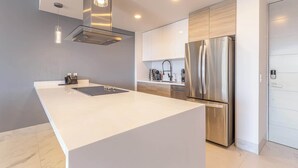 Eine moderne Küche mit einer großen Kochinsel, Edelstahlgeräten und einem minimalistischen Design.