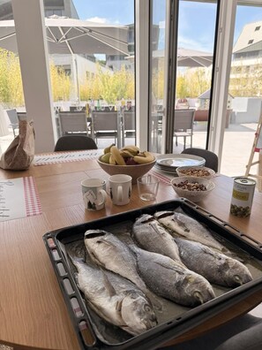 Ein Esstisch mit einer Fischplatte, einer Bananenschale und einer Olivenbüchse.