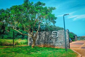 A stone wall with a sign for 'The Boulevard' in a landscaped area with a tree and a street lamp. - Zimbali Lakes Boulevard Edge 103 (Ballito)