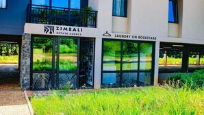 Un edificio con un letrero que dice 'ZIMBALI ESTATE AGENCY' y 'LAUNDRY ON BOULEVARD'.