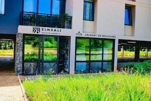 A building with a sign for 'ZIMBALI ESTATE AGENCY' and 'LAUNDRY ON BOULEVARD.' - Zimbali Lakes Boulevard Edge 103 (Ballito)