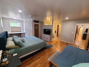 A bedroom with a bed, a desk, a TV, and a ceiling fan. - New! Starlight Pines! Grill/AC/Dog Friendly! (Flagstaff)