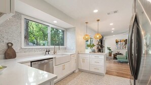 A modern kitchen with white cabinetry, a large window, and pendant lighting. - Near Downtown, 4BR, Austin Heart, Large Backyard (Austin)