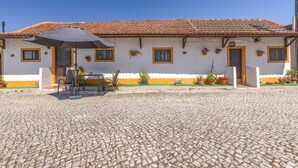 A building with a tiled roof, a cobblestone courtyard, and potted plants on the exterior. - Vila Natura – Secret Retreat S2 with Shared Terrace & Garden, Wi-Fi (Santo António da Charneca)