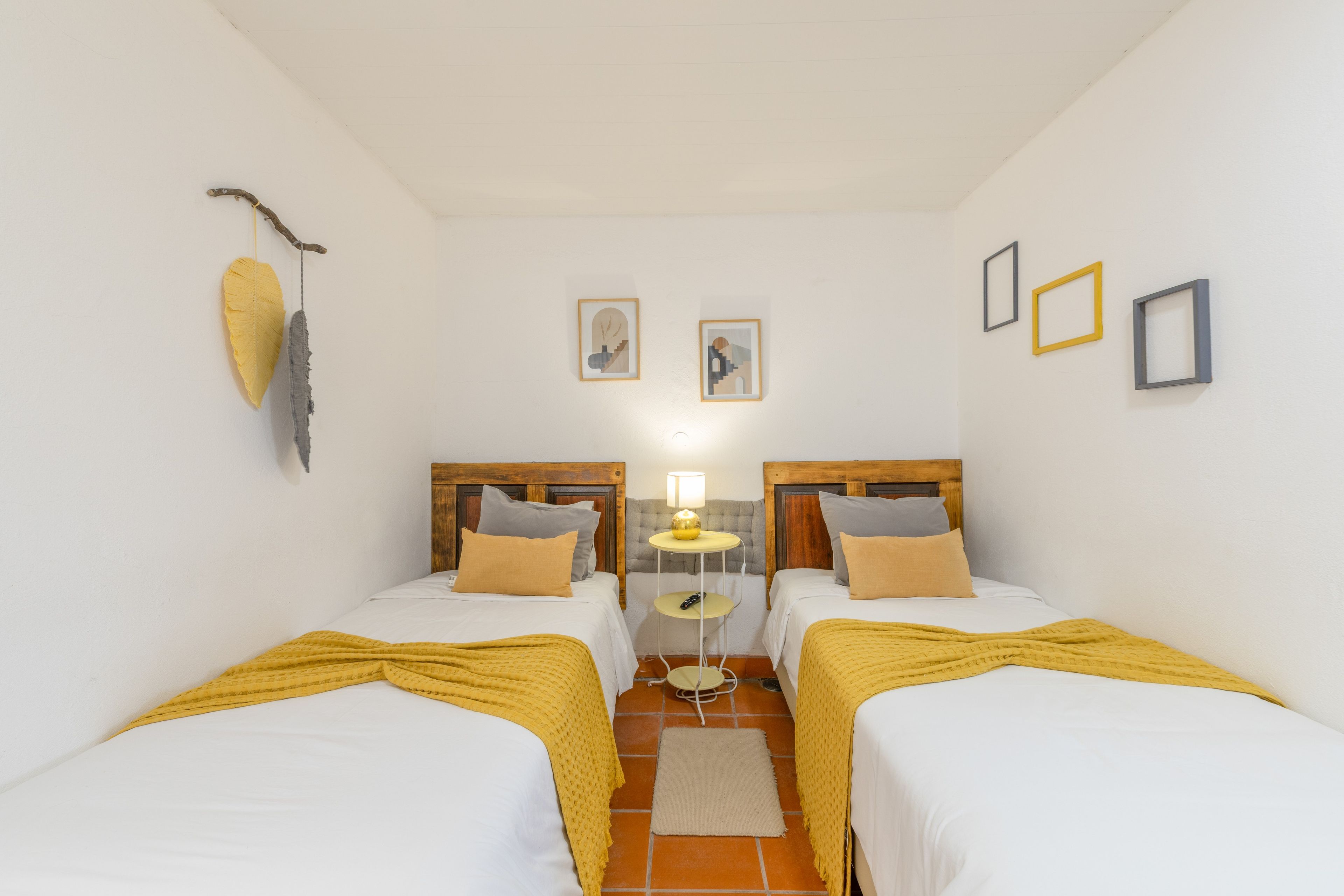 Une chambre d’hôtel avec deux lits, une petite table et une lampe.