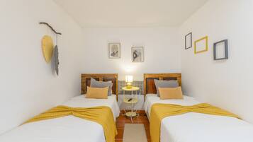Une chambre d’hôtel avec deux lits, une petite table et une lampe.