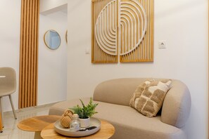 Ein modernes Wohnzimmer mit einer Couch, einem runden Couchtisch und dekorativen Wandbildern.