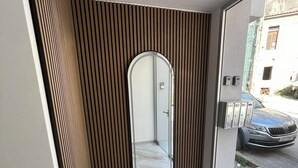 Decoração moderna com um espelho grande, painel de parede em madeira e vista para a rua.