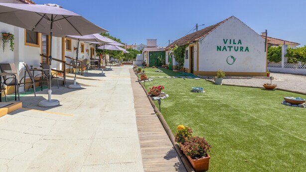 A courtyard with outdoor seating, a green lawn, and a building labeled 'Vila Natura'. - Vila Natura – Secret Retreat S4 with Shared Terrace & Garden, Wi-Fi (Santo António da Charneca)