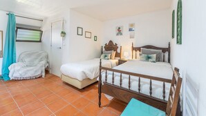 A bedroom with two beds, a window with a curtain, and a small chair. - Vila Natura – Secret Retreat S4 with Shared Terrace & Garden, Wi-Fi (Santo António da Charneca)