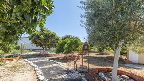 A garden area with a pathway, trees, and a sign that reads 'HOTEL INSECTS.' - Vila Natura – Secret Retreat S4 with Shared Terrace & Garden, Wi-Fi (Santo António da Charneca)