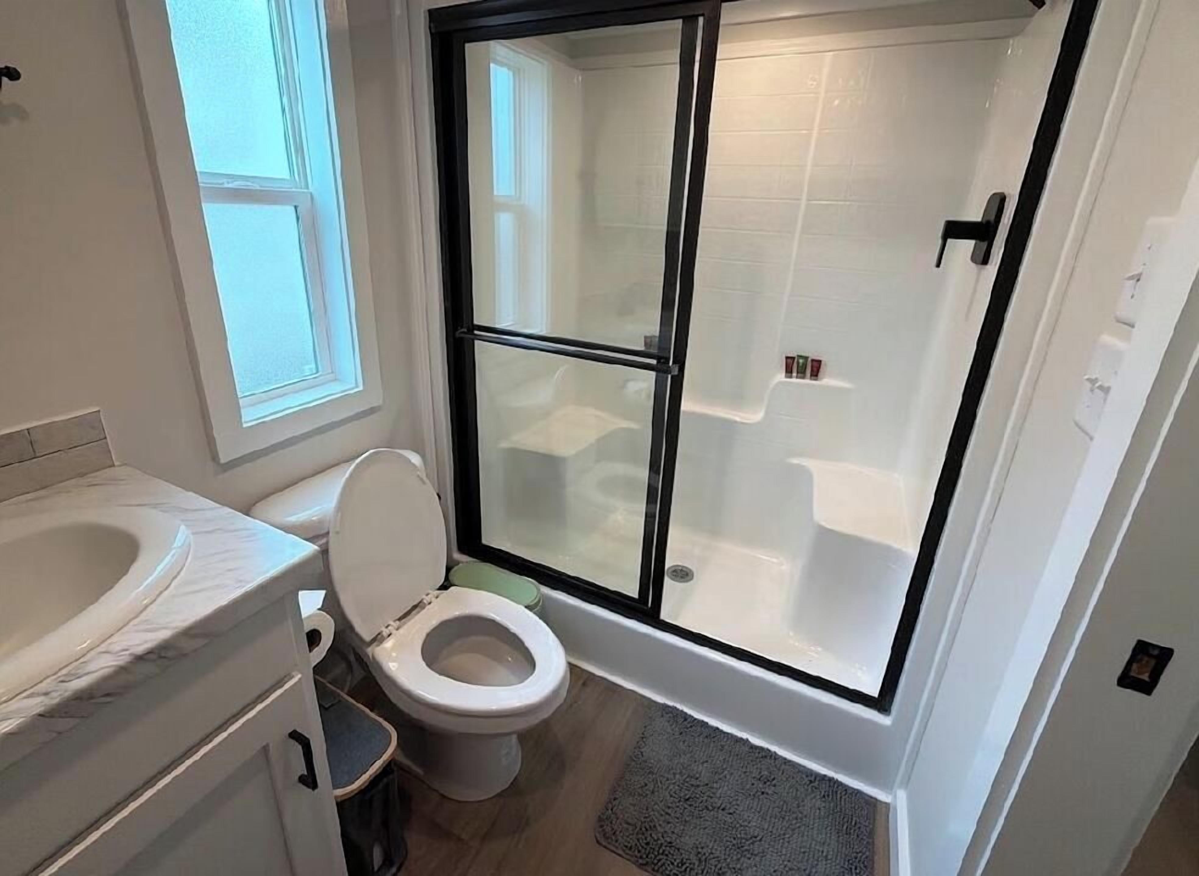 Een badkamer met toilet, bad en douchecabine.