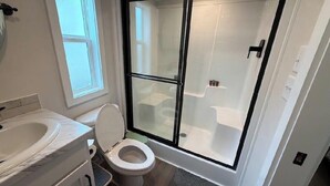 Ein Badezimmer mit Toilette, Waschbecken und Duschkabine.