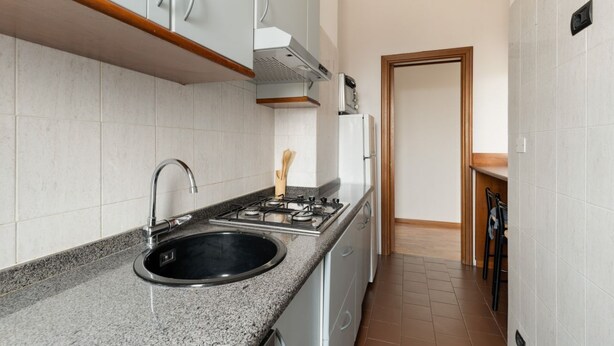A kitchen with a granite countertop, stainless steel sink, and a gas stove. - Cozy 70m2 apartment, ideal for 4 people, located on the eighth floor of a building with lift (5 steps to access it).The accommodation is located in a quiet residential area, known for its proximity to the Parco Nord Milano.Served by the Milan Affori stat (Milan)