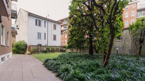 A paved pathway leading to a building with a white facade and a tree-lined garden. - Cozy 70m2 apartment, ideal for 4 people, located on the eighth floor of a building with lift (5 steps to access it).The accommodation is located in a quiet residential area, known for its proximity to the Parco Nord Milano.Served by the Milan Affori stat (Milan)