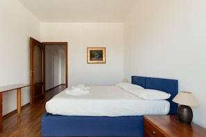 A bedroom with a bed, bedside table, lamp, and a painting on the wall. - Cozy 70m2 apartment, ideal for 4 people, located on the eighth floor of a building with lift (5 steps to access it).The accommodation is located in a quiet residential area, known for its proximity to the Parco Nord Milano.Served by the Milan Affori stat (Milan)