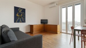 A modern living room with a grey sofa, wooden cabinet, and a flat-screen TV. - Cozy 70m2 apartment, ideal for 4 people, located on the eighth floor of a building with lift (5 steps to access it).The accommodation is located in a quiet residential area, known for its proximity to the Parco Nord Milano.Served by the Milan Affori stat (Milan)