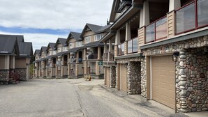 A row of townhouses with stone walls, balconies, and garage doors. - Modern Mountain Retreat - Walk to Village + HotTub (Beaverdell)