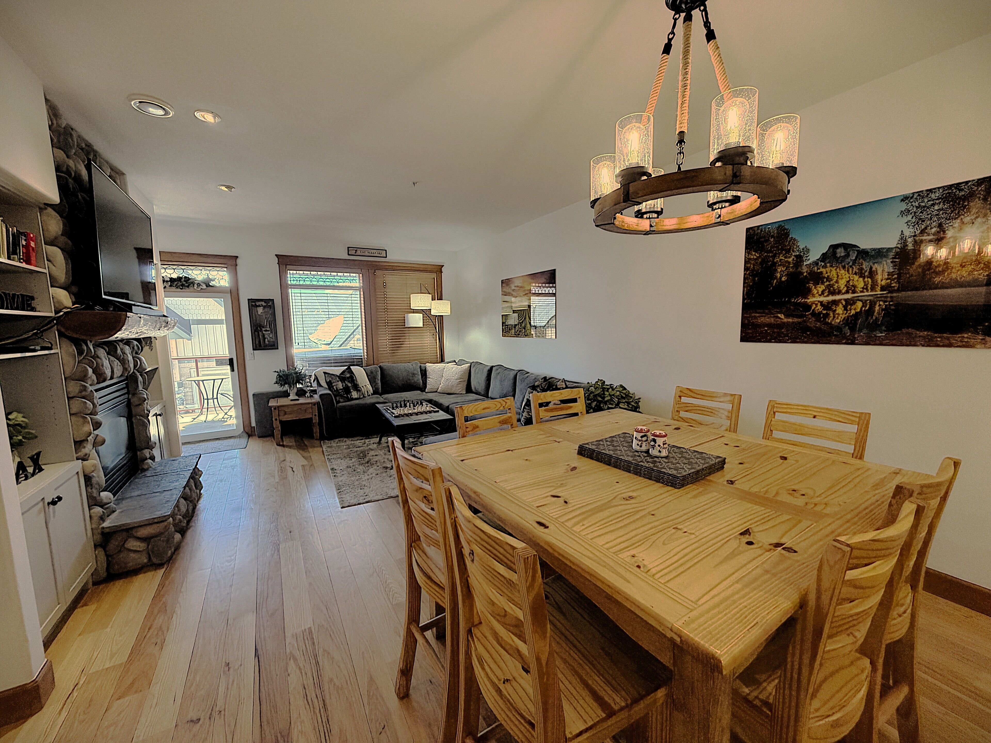 Un vaste espace de vie comprenant une table à manger en bois, un canapé et une cheminée.