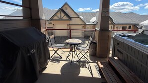 A covered patio with a hot tub, a table, and chairs. - Modern Mountain Retreat - Walk to Village + HotTub (Beaverdell)