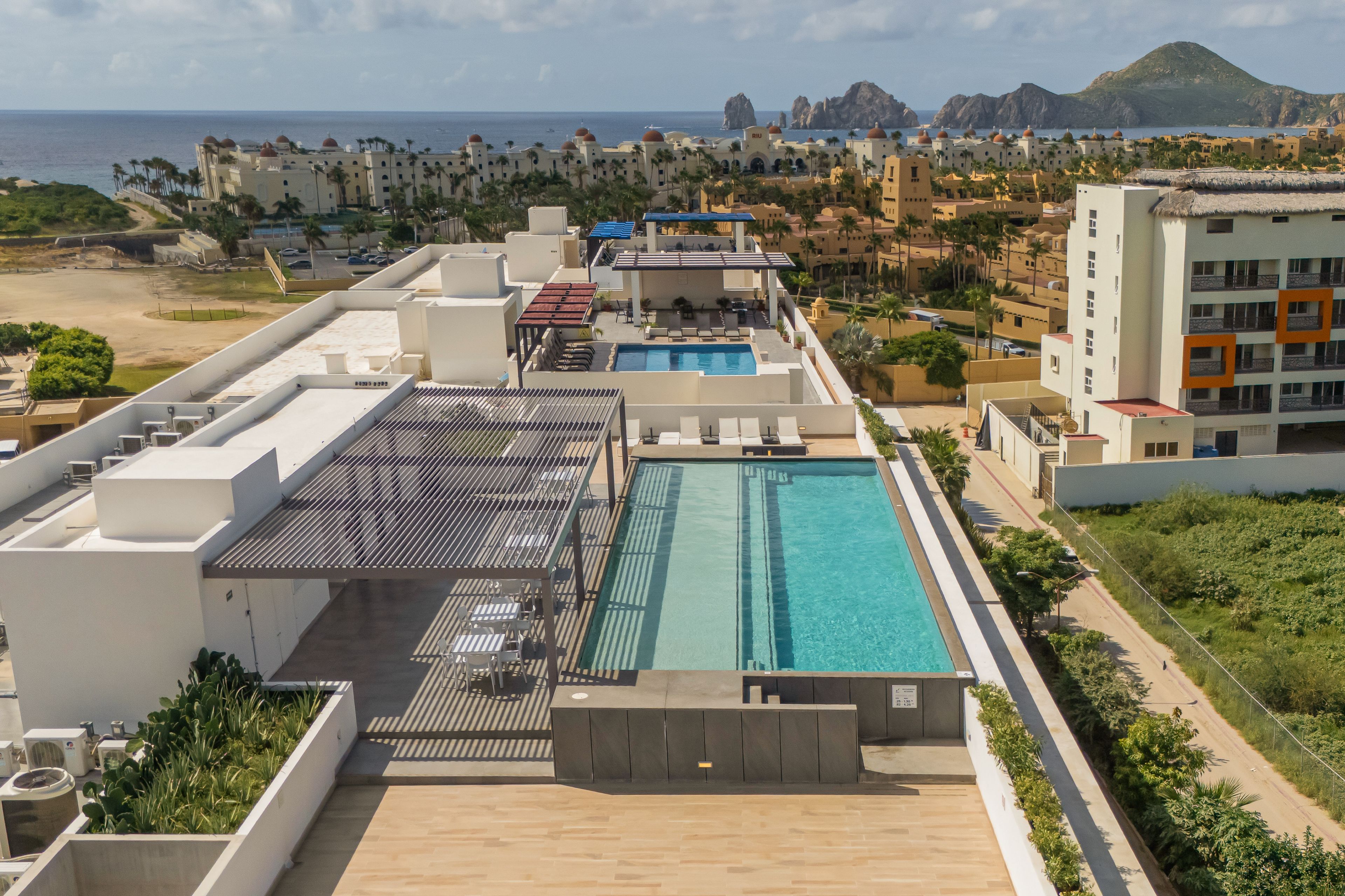 A rooftop pool with a view of the beach and mountains.