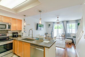 Eine moderne Küche mit Granit Arbeitsplatten, Edelstahlgeräten und Holzschränken.