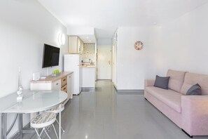 Ein zeitgemäßer Wohnraum mit Küche, Essbereich und einer Couch.