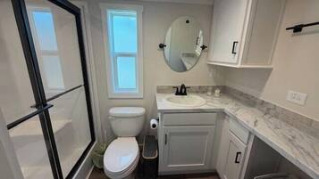 Une petite salle de bain comprenant des toilettes, un lavabo et un miroir.