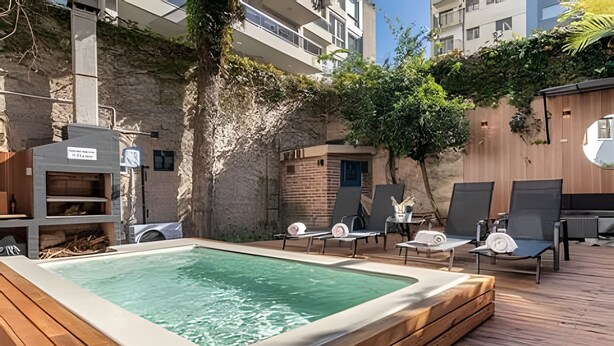 Ein Poolbereich auf dem Dach mit Liegestühlen und einem Whirlpool.