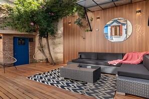 A modern outdoor seating area with a sofa, a chair, and a patterned rug. - House in Soho Heated Pool, BBQ Grill & Playroom (Buenos Aires)