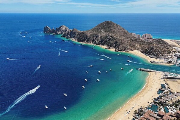 Vista aérea de una zona costera con barcos, una playa y edificios.