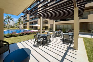 Um pátio moderno ao ar livre com piscina, área de estar externa e vista para a piscina.