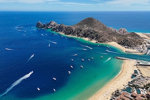 Eine Luftaufnahme einer Küstenregion mit Strand, Booten und Gebäuden.