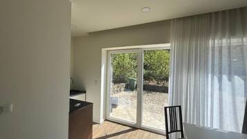 Una habitación con puerta corrediza de vidrio que da a un espacio al aire libre, una mesa de comedor y una encimera de cocina.